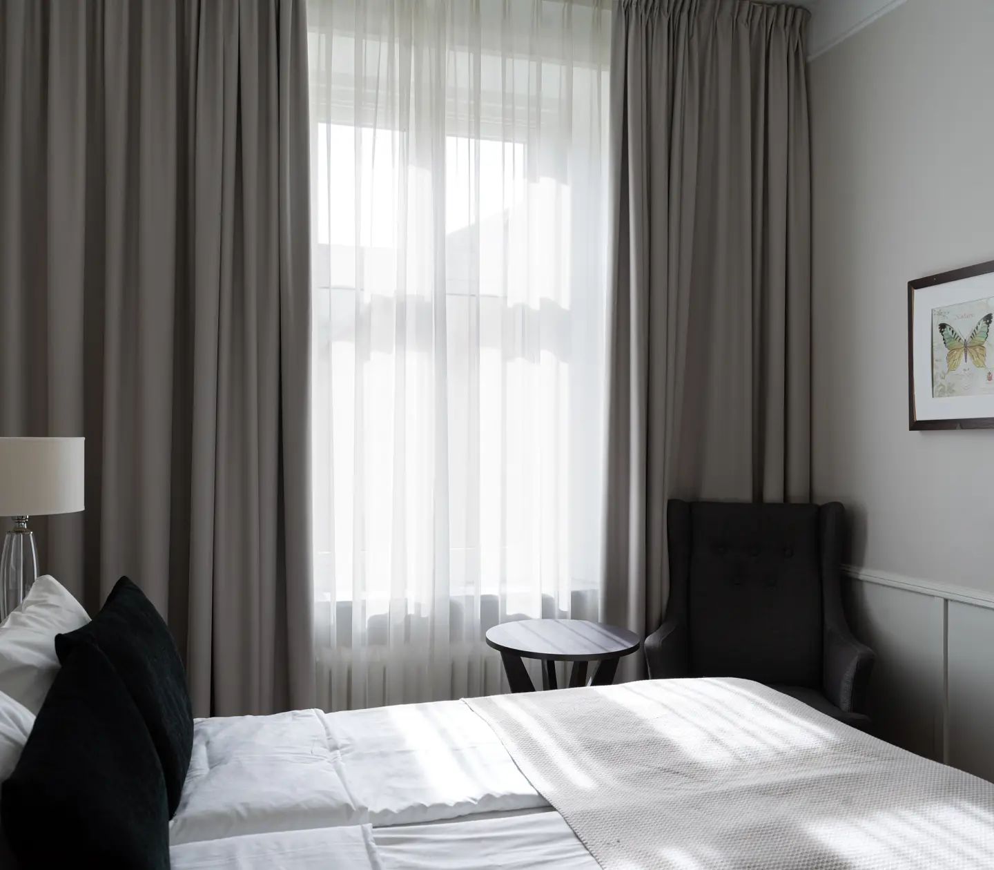 Hotellrum med dubbelsäng, tv, skrivbord och fönster