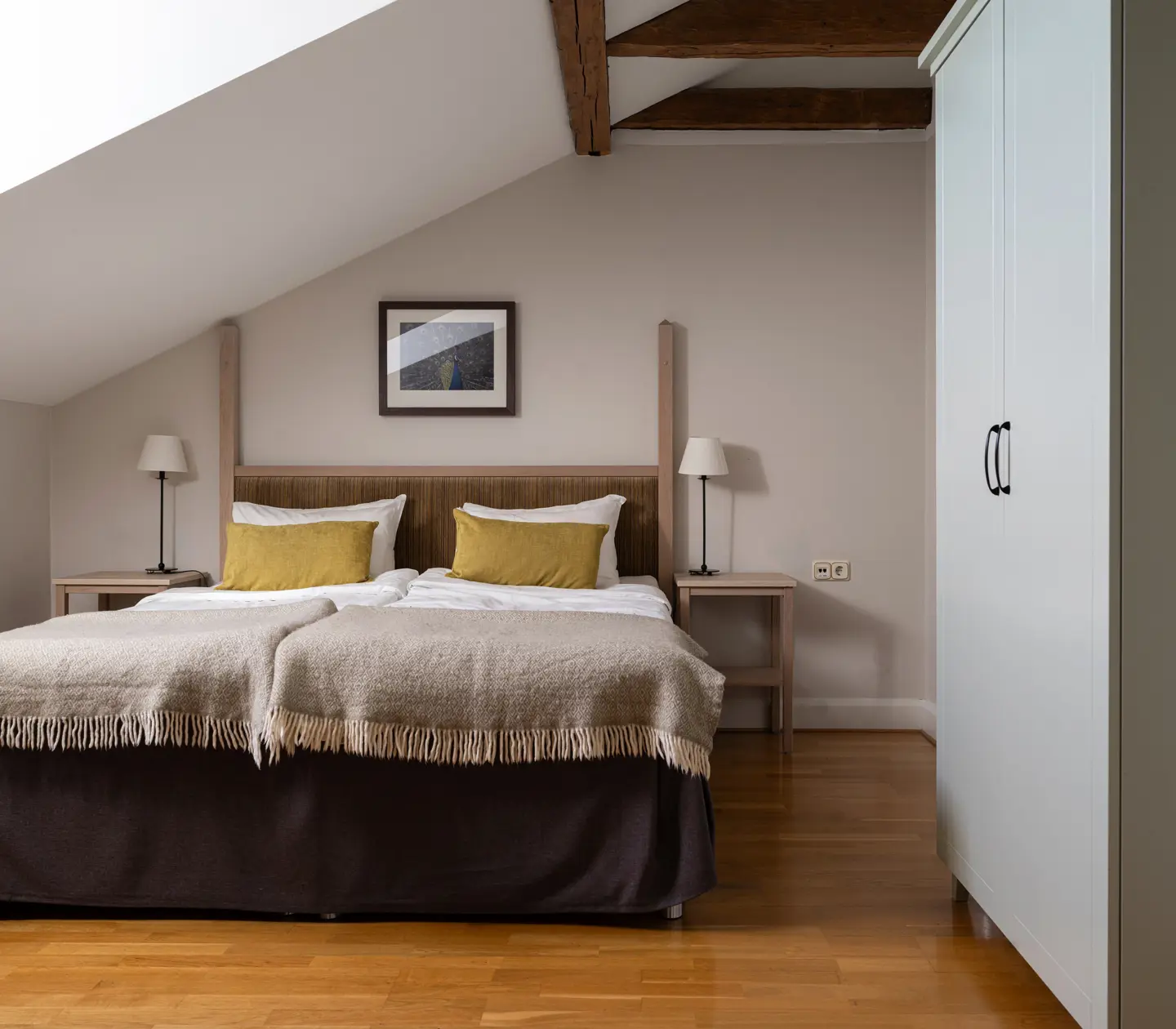 Hotellrum med dubbelsäng, fåtölj och fönster