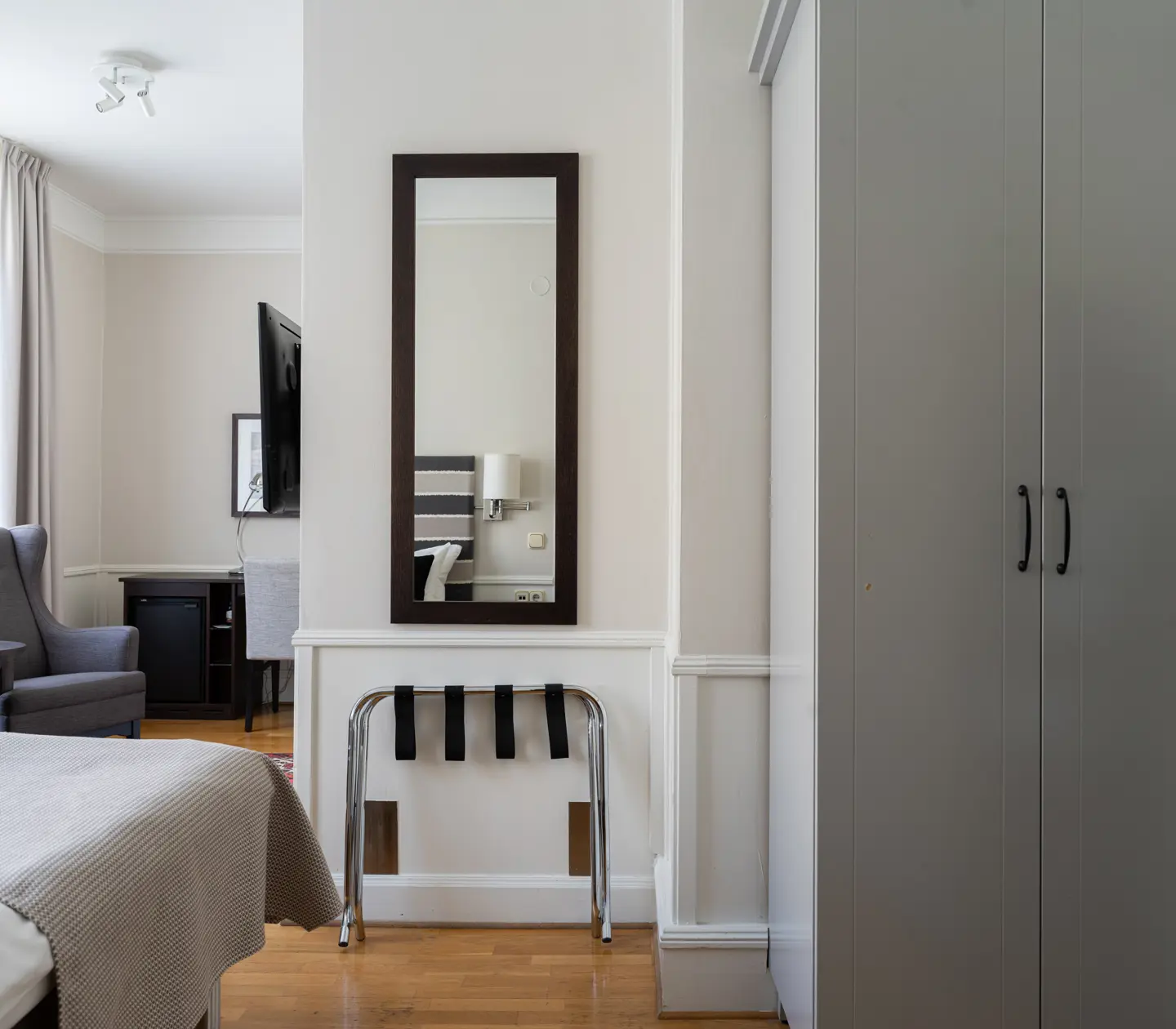 Hotellrum med dubbelsäng, fåtölj och fönster