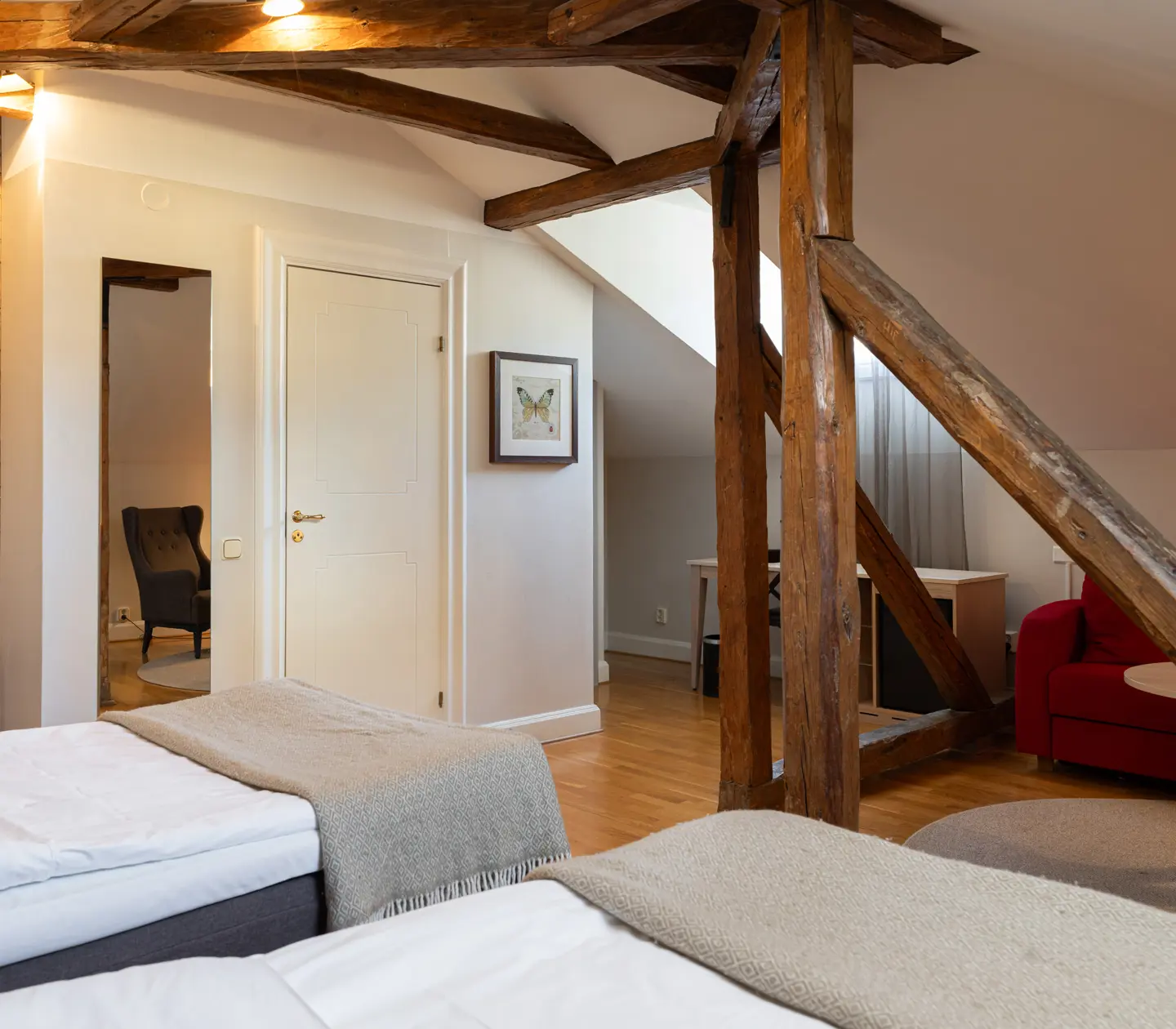 Mysigt hotellrum med dubbelsäng, skrivbord och fåtöljer
