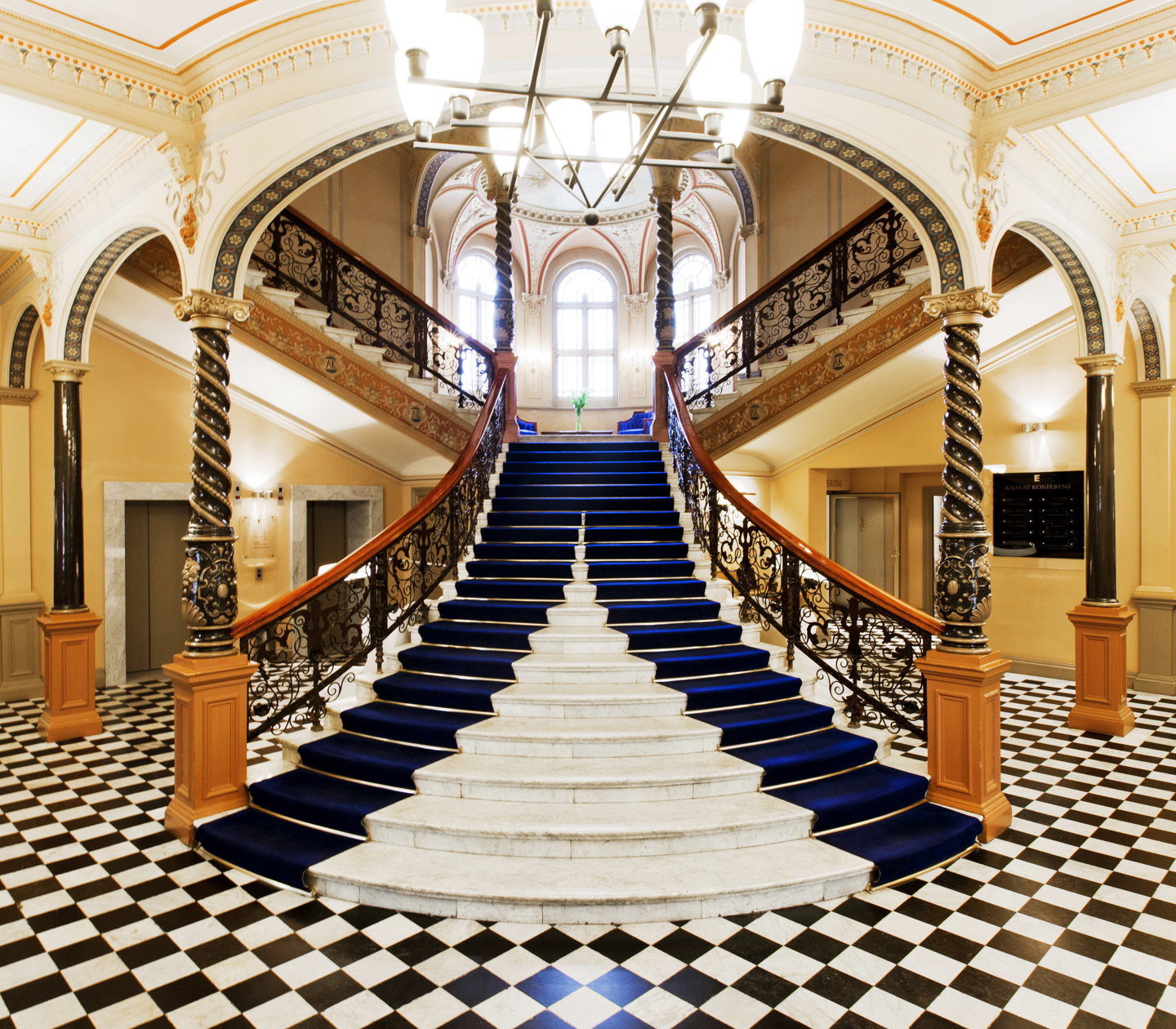Pampiga trappa med mycket dekorationer i hotellobby med schackrutigt golv