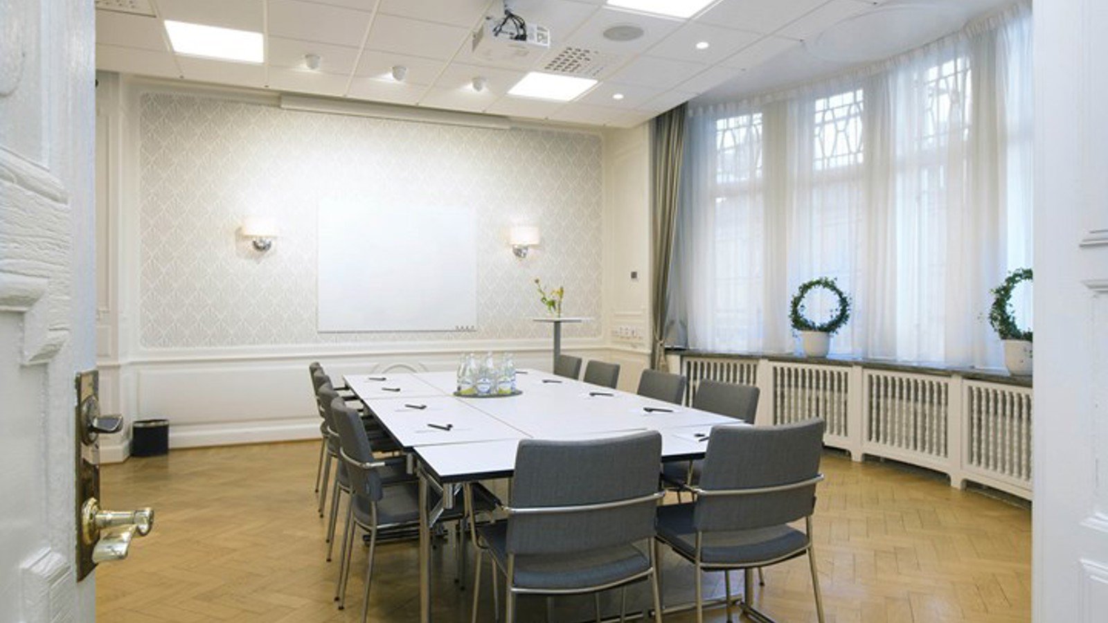Conference room with board seating, gray chairs, white walls