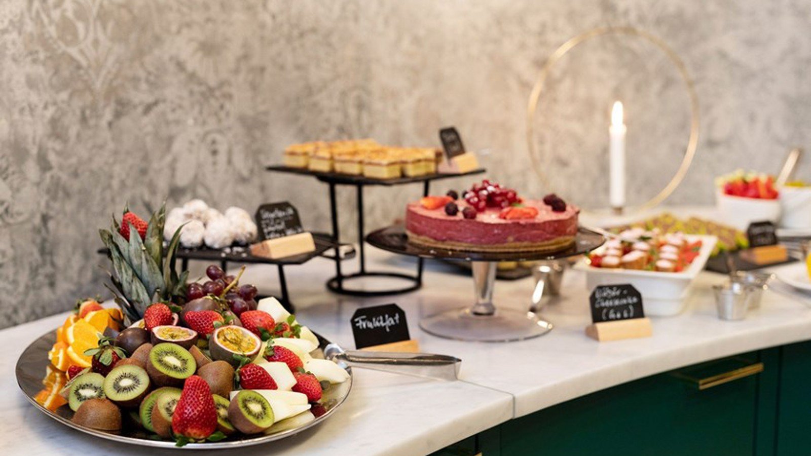 A food buffet with fruit and pastries
