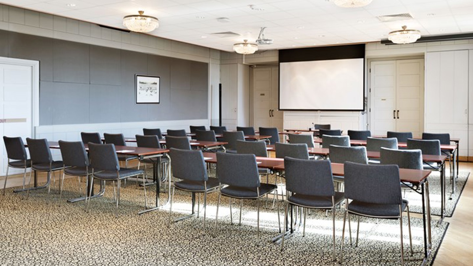 Konferensrum med biosittning, projektor, grå matta och grå stolar