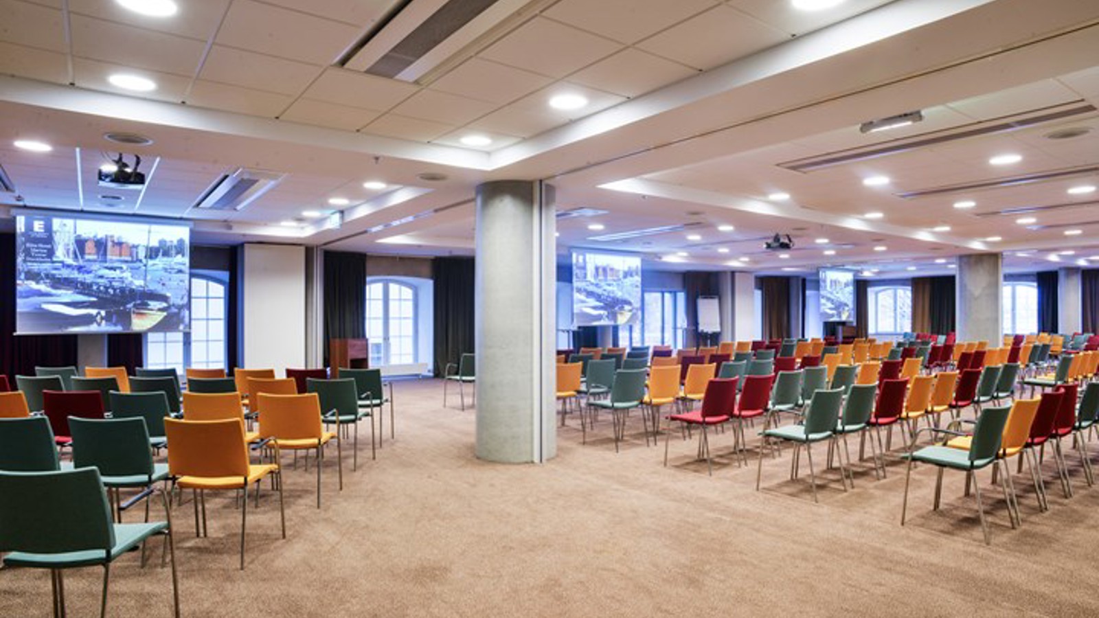 Konferensrum med biosittning, färgglada stolar och många fönster