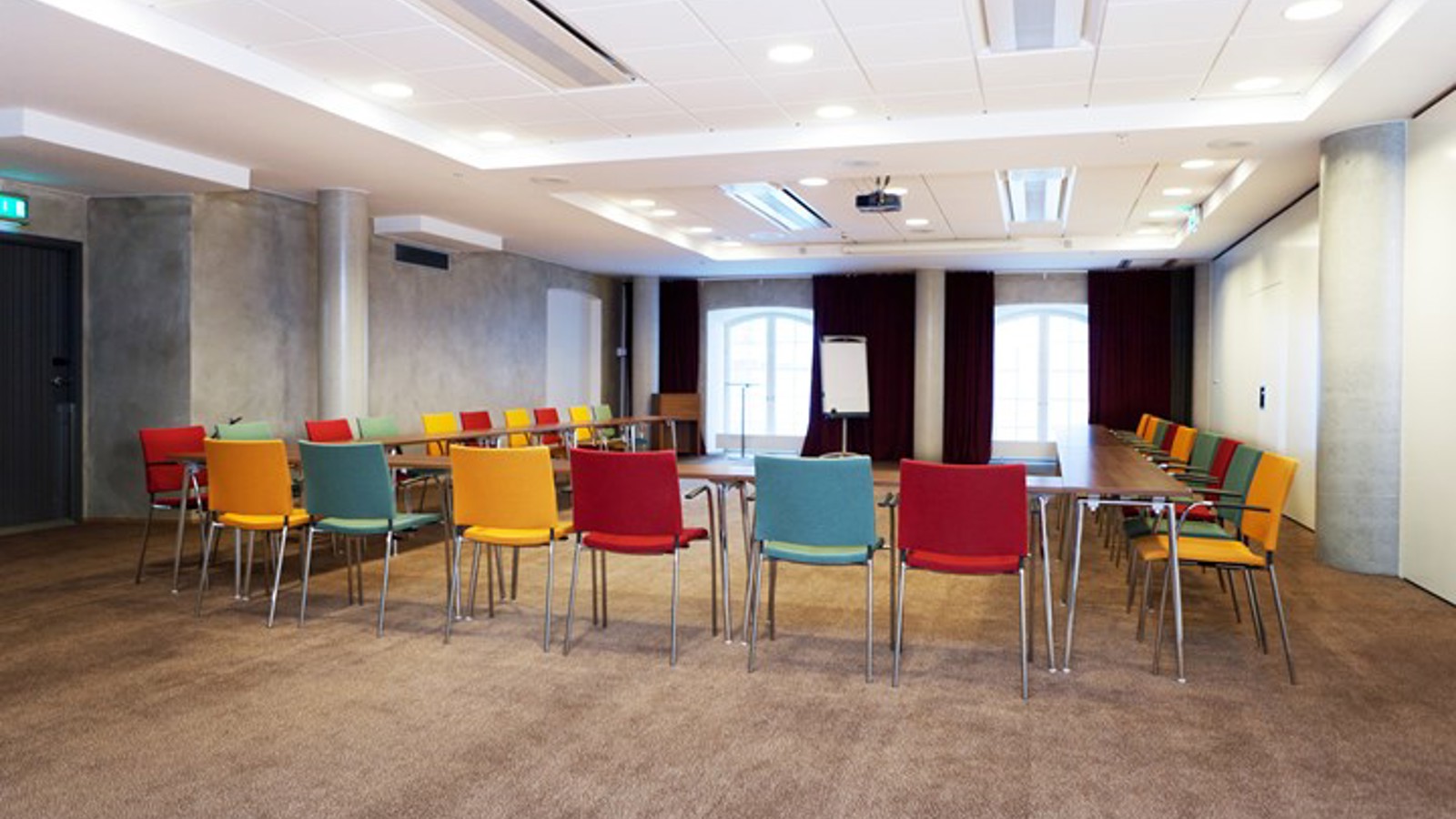 Konferensrum med u-sittning och färgglada stolar