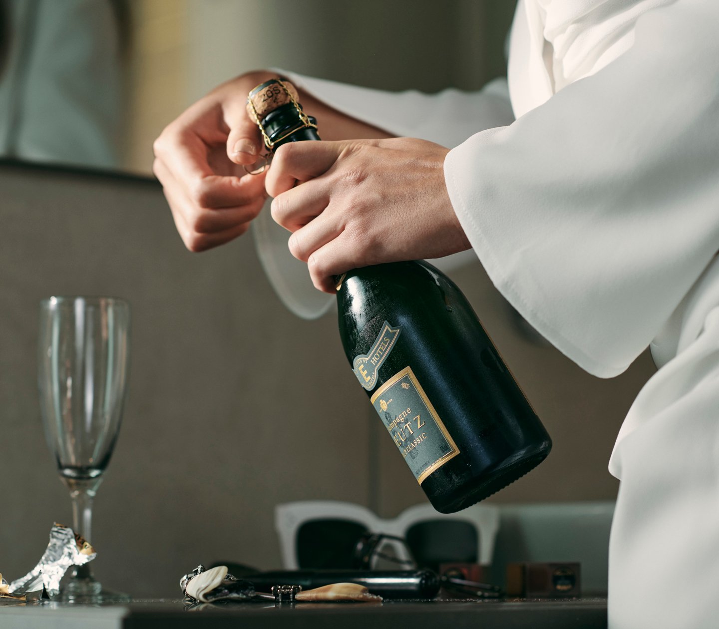 Waiter opens a champagne bottle
