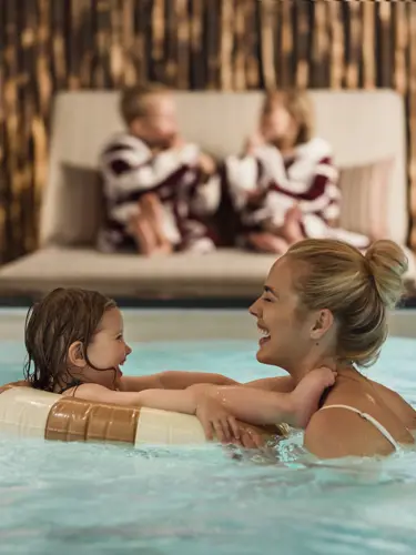 Mamma och dotter lekande i pool