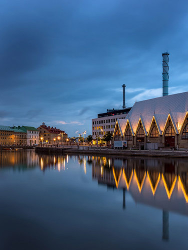 Feskekôrkan i Göteborg i skymning med vattnet framför