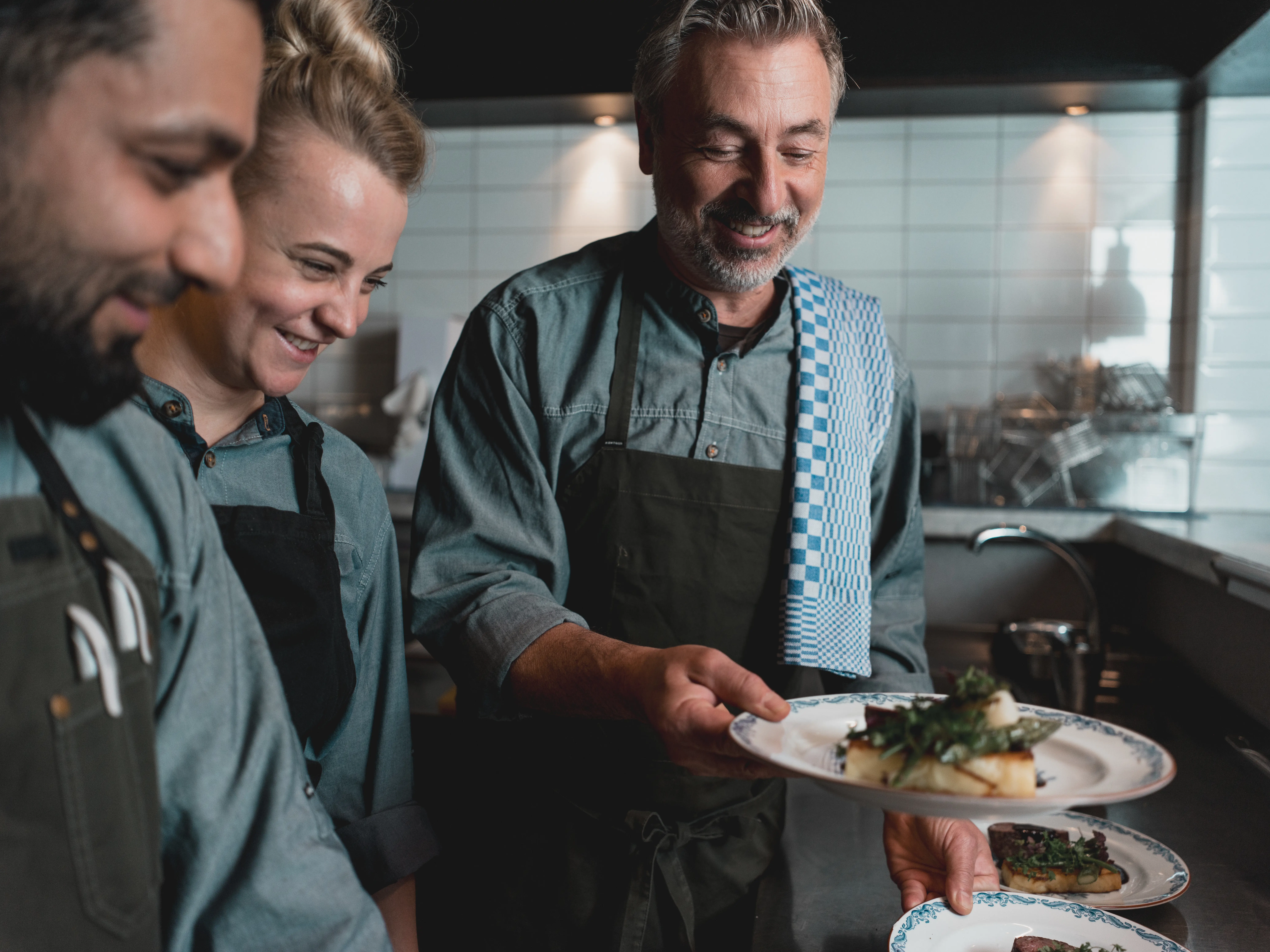 Kockar i ett restaurangkök förbereder och serverar maträtter