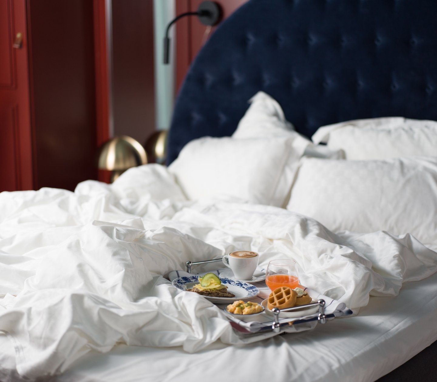 Women in a hotel bed with breakfast tray