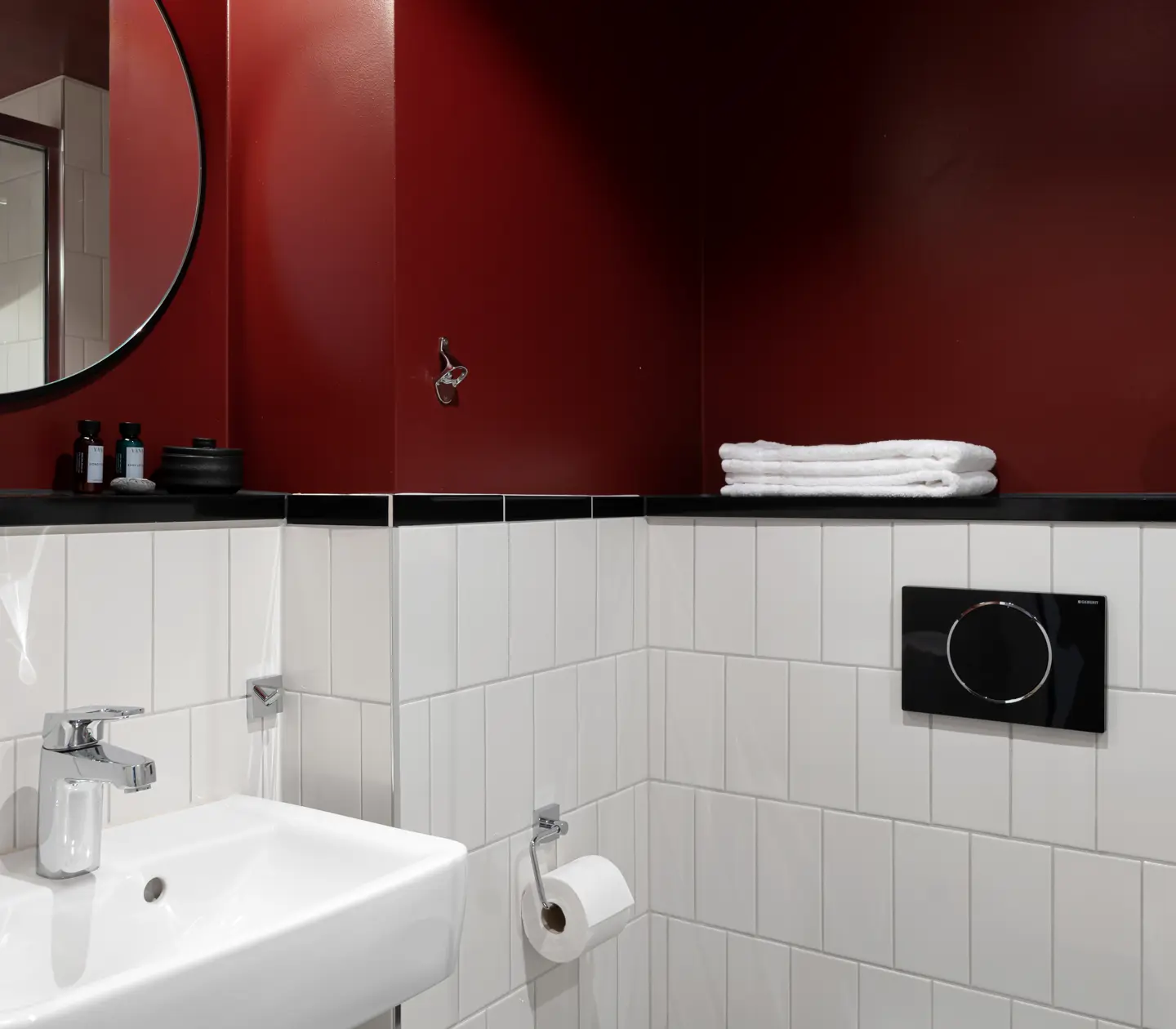 Red bathroom with sink and round mirror