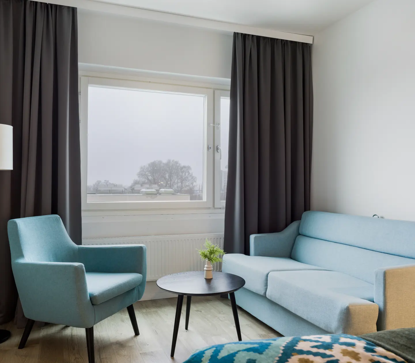 Hotel room with sofa, armchair and window