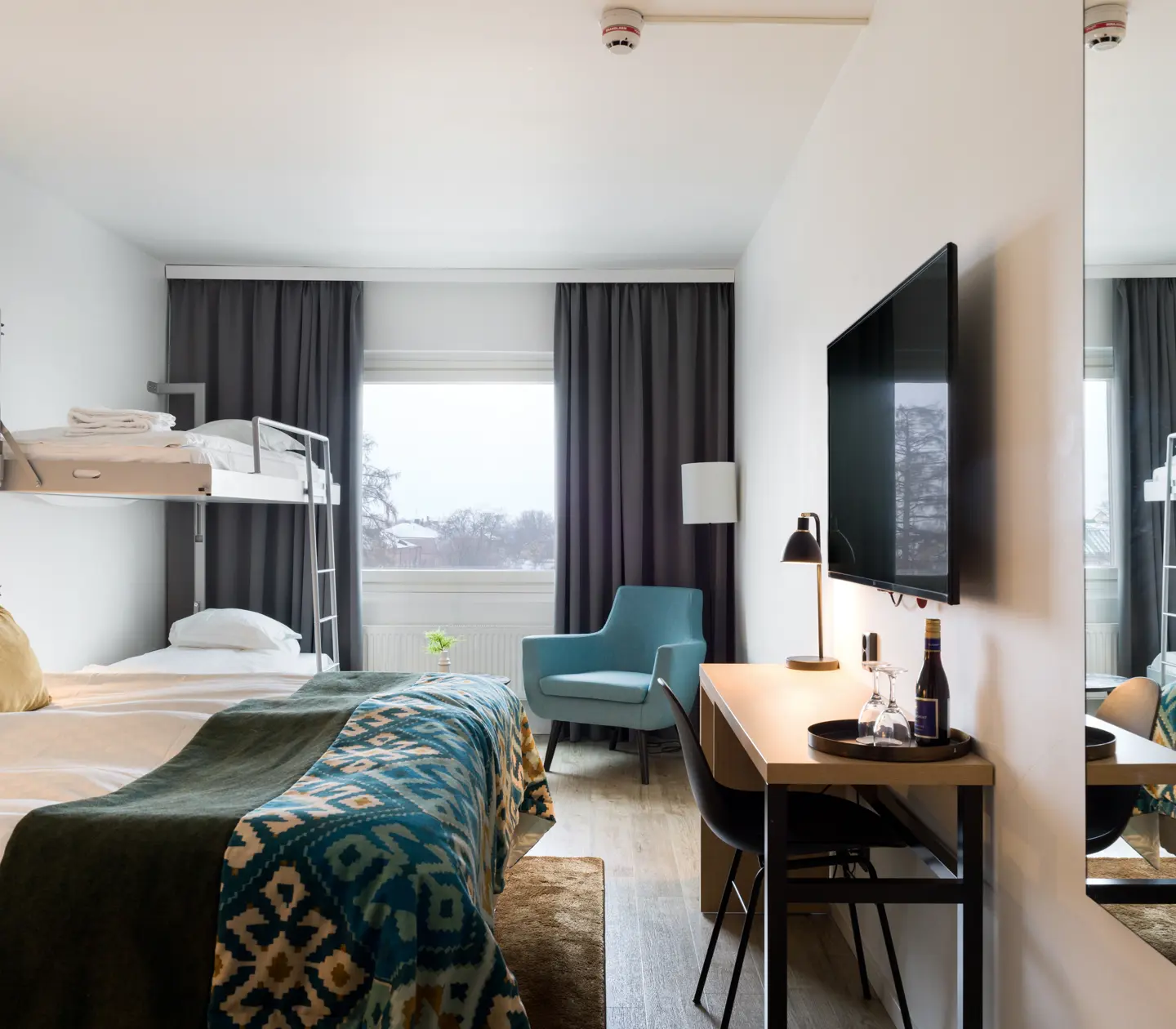 Hotel room with double bed, bunk bed and desk