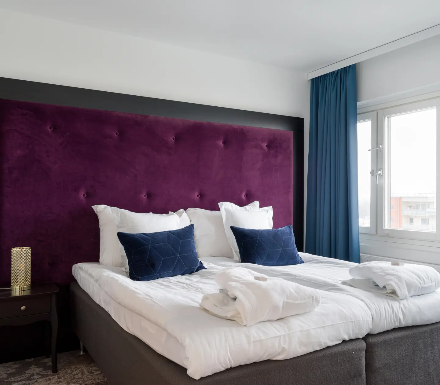 Suite with double bed and purple headboard