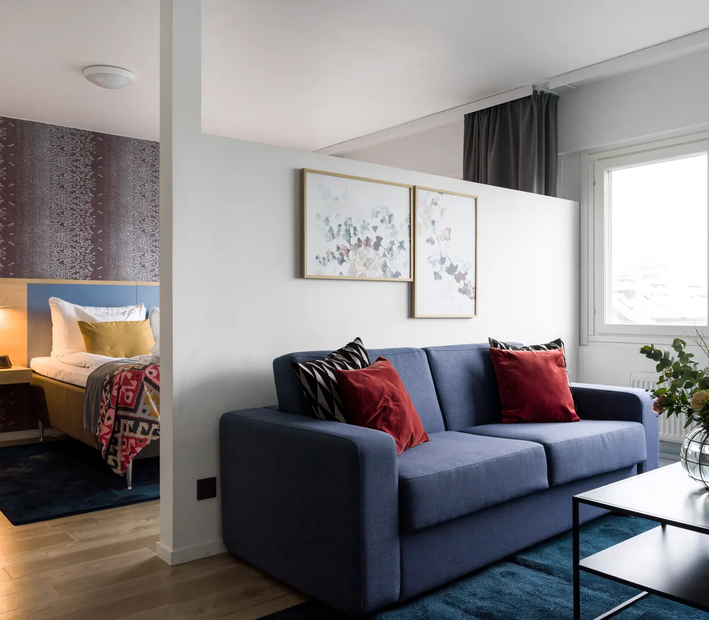Hotel room with sofa bed and flower bouquet