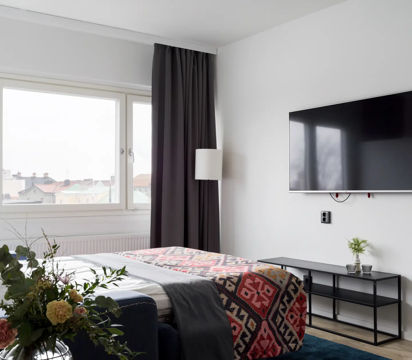 Bright hotel room with double bed, TV and window