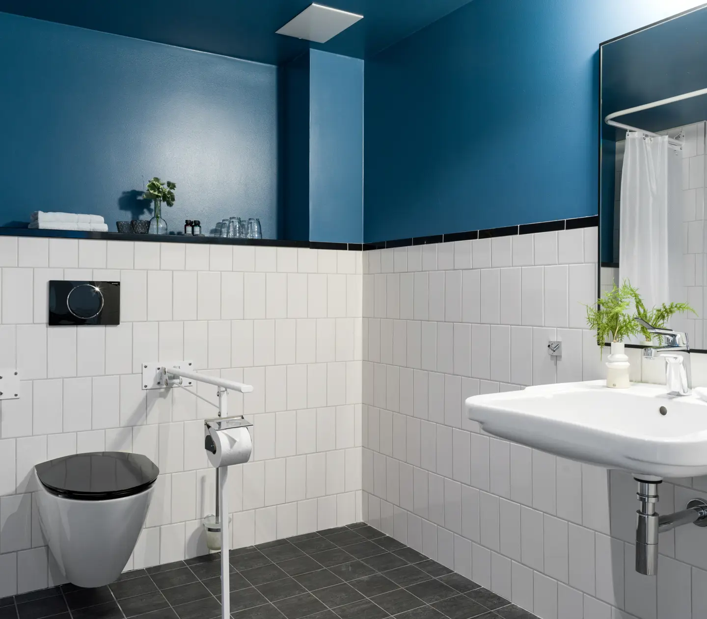 Blue bathroom with toilet, mirror and sink