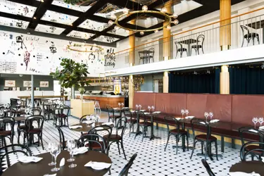 Restaurang med bord, stolar och väggmålningar