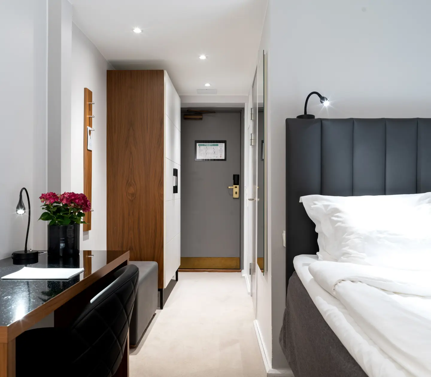 Single room with bed, desk and wardrobe