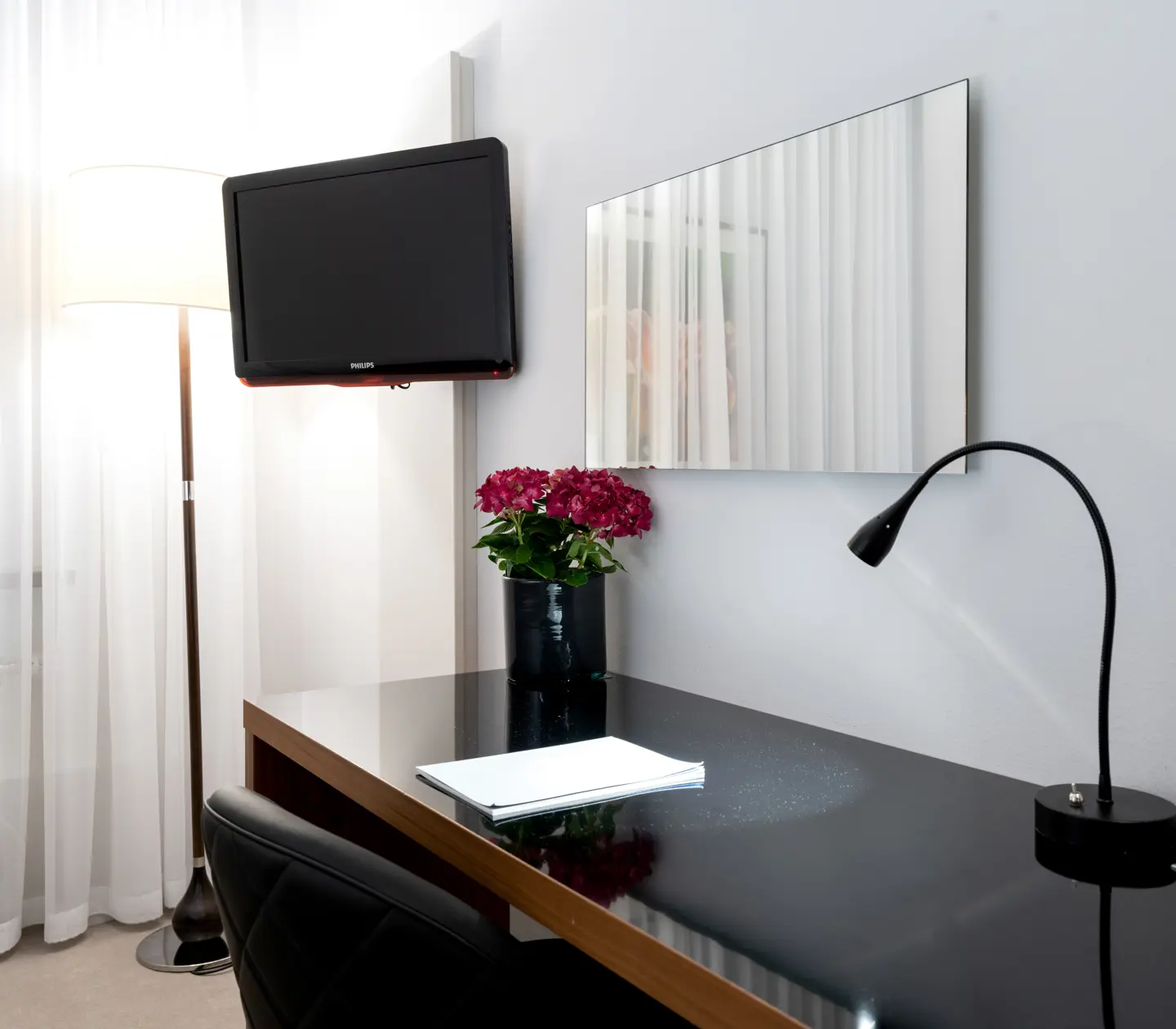 Hotel room with desk, mirror and TV