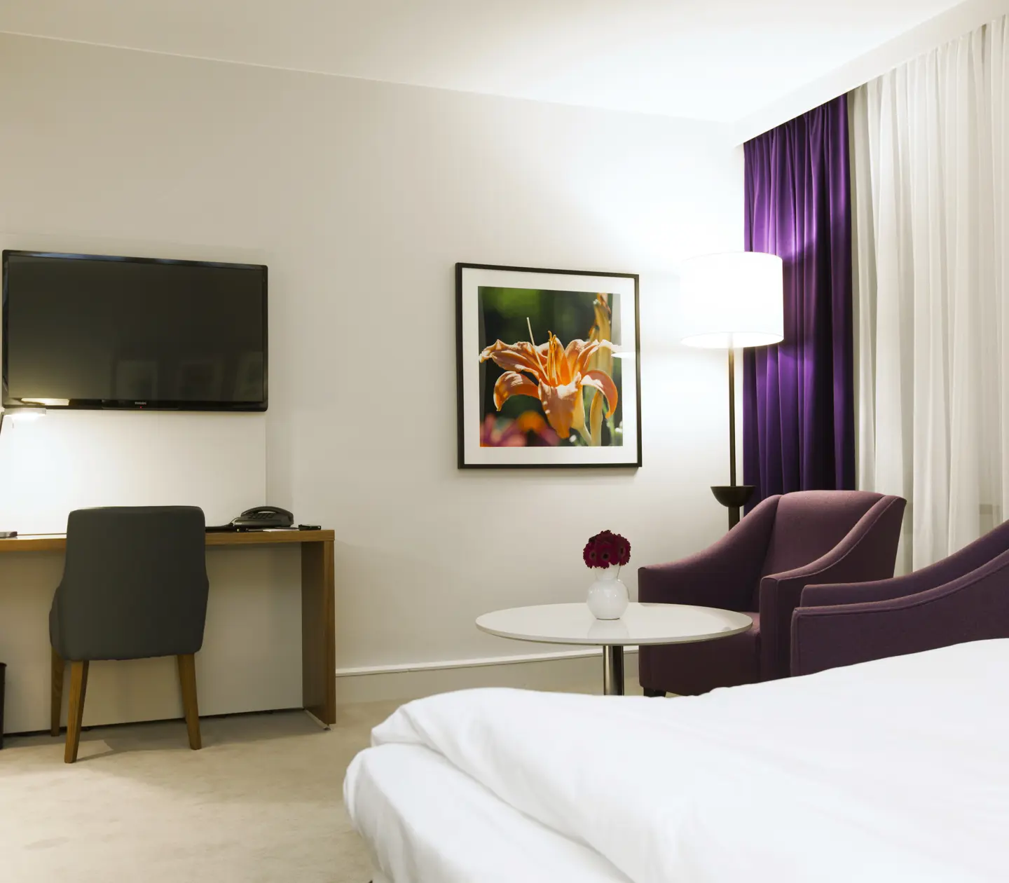 Hotel room with desk, armchairs and TV