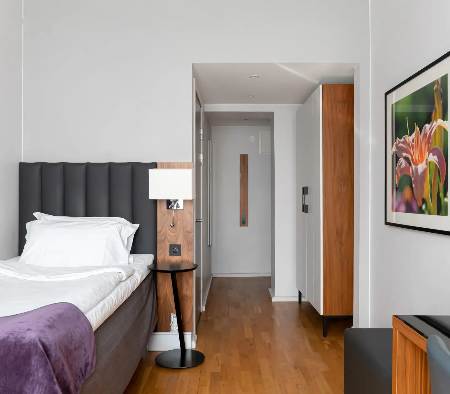 Hotel room with single bed, blackboard and wardrobe