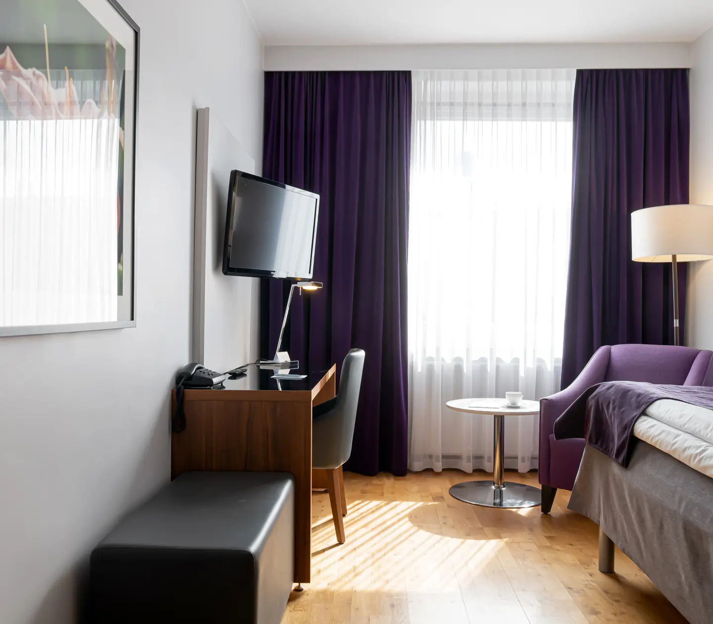 Hotel room with bed, armchair and desk