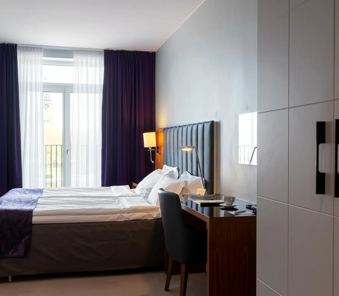 Hotel room with double bed, desk and window