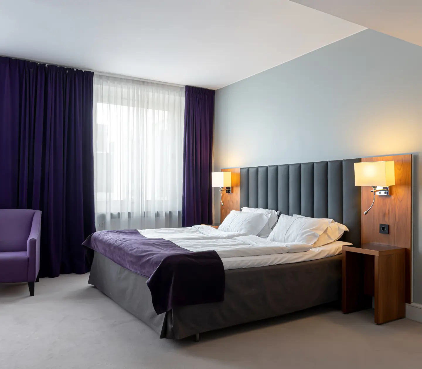 Hotel room with double bed, armchair and window