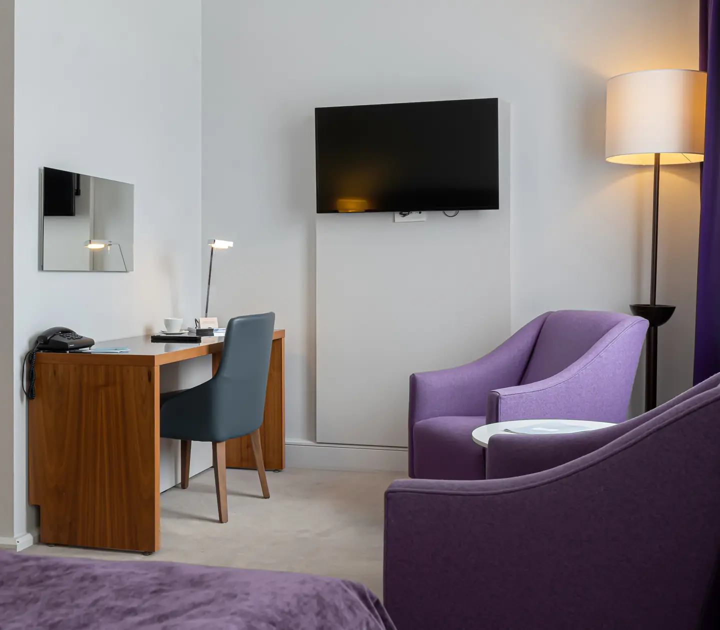 Hotel room with armchairs, desk and television