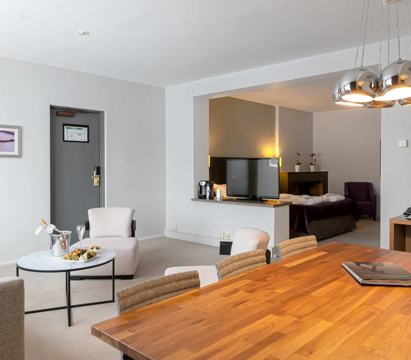 Suite with dining table, TV and armchairs