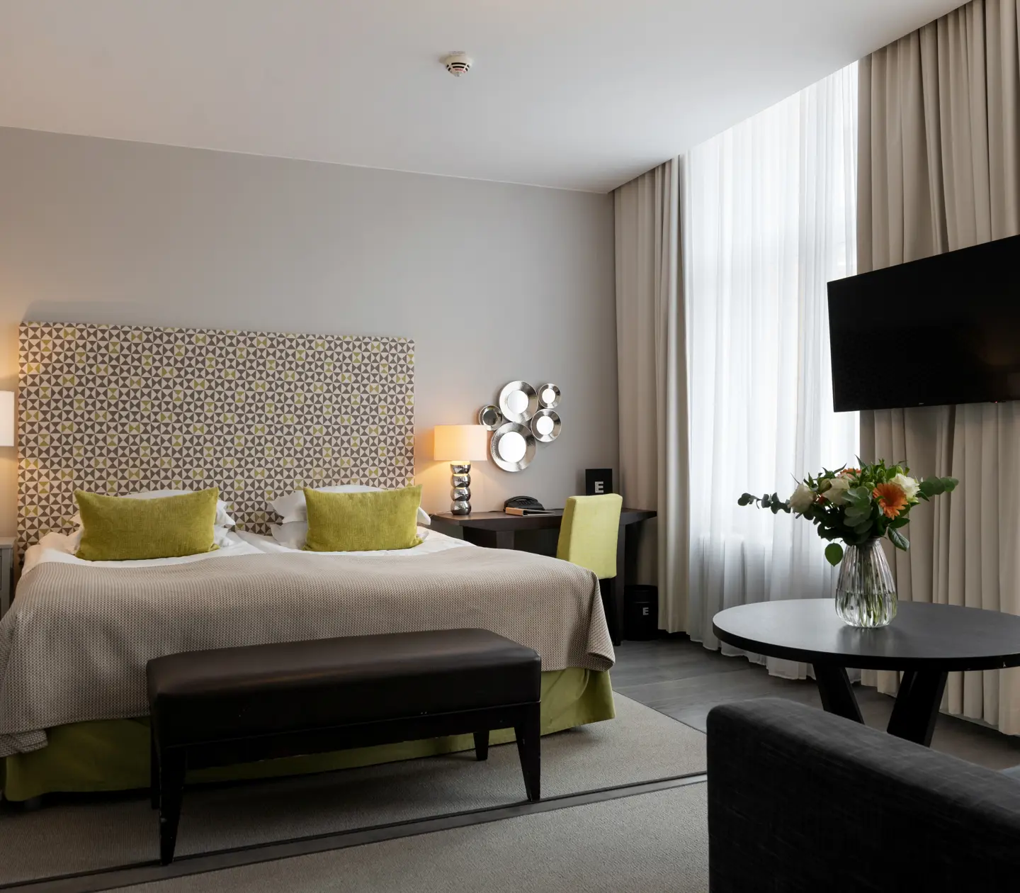 Hotellrum med dubbelsäng, soffa och skrivbord