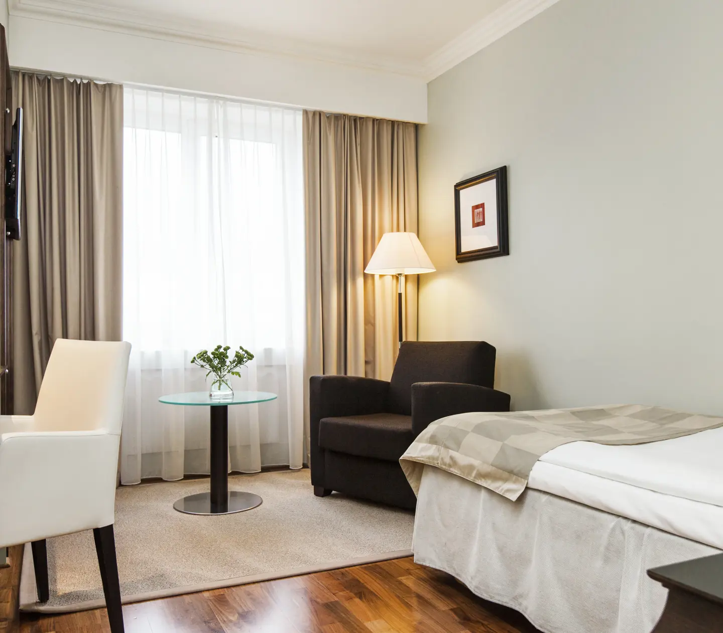 Cozy hotel room with single bed, armchair and desk