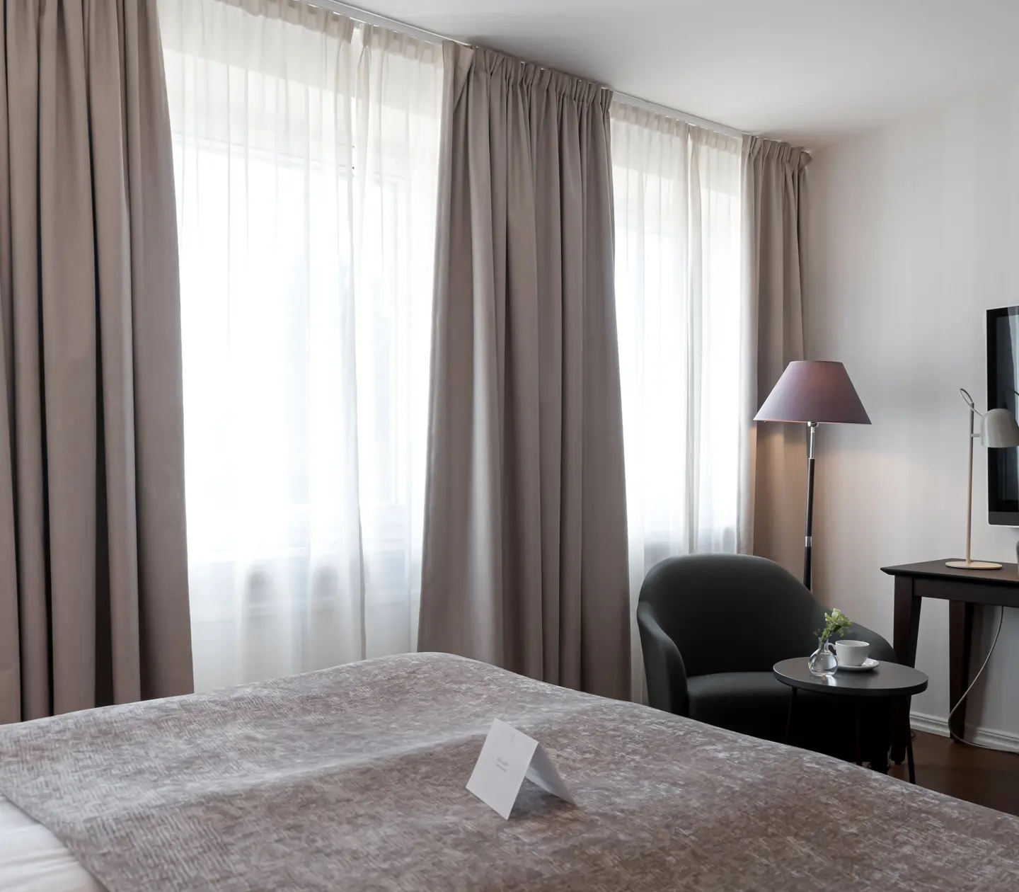 Hotel room with desk, armchair and large windows