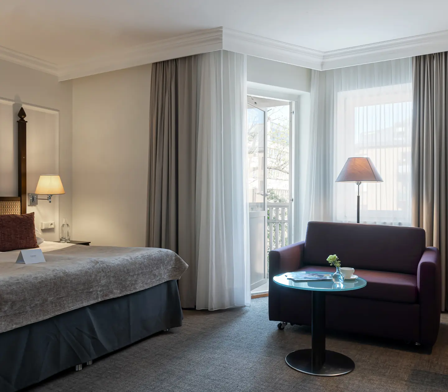 Hotel room with double bed, sofa and balcony door