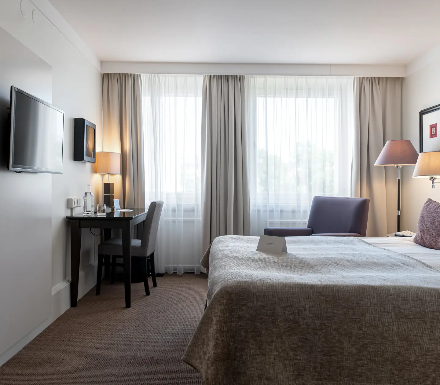 Hotel room with double bed, desk and window