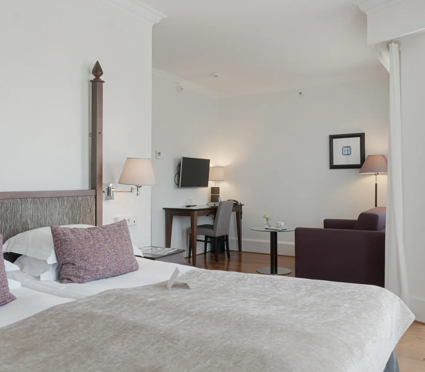 Cozy hotel room with double bed, armchair and desk