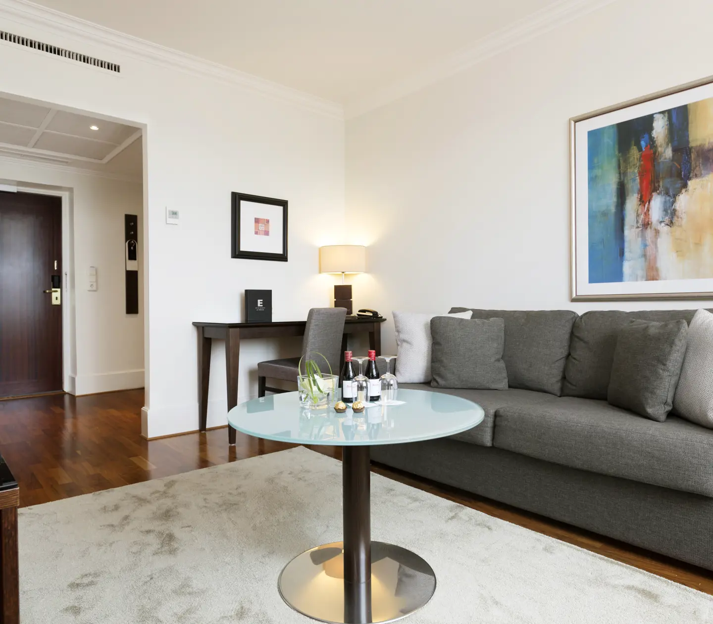 Hotel room with sofa, desk and paintings