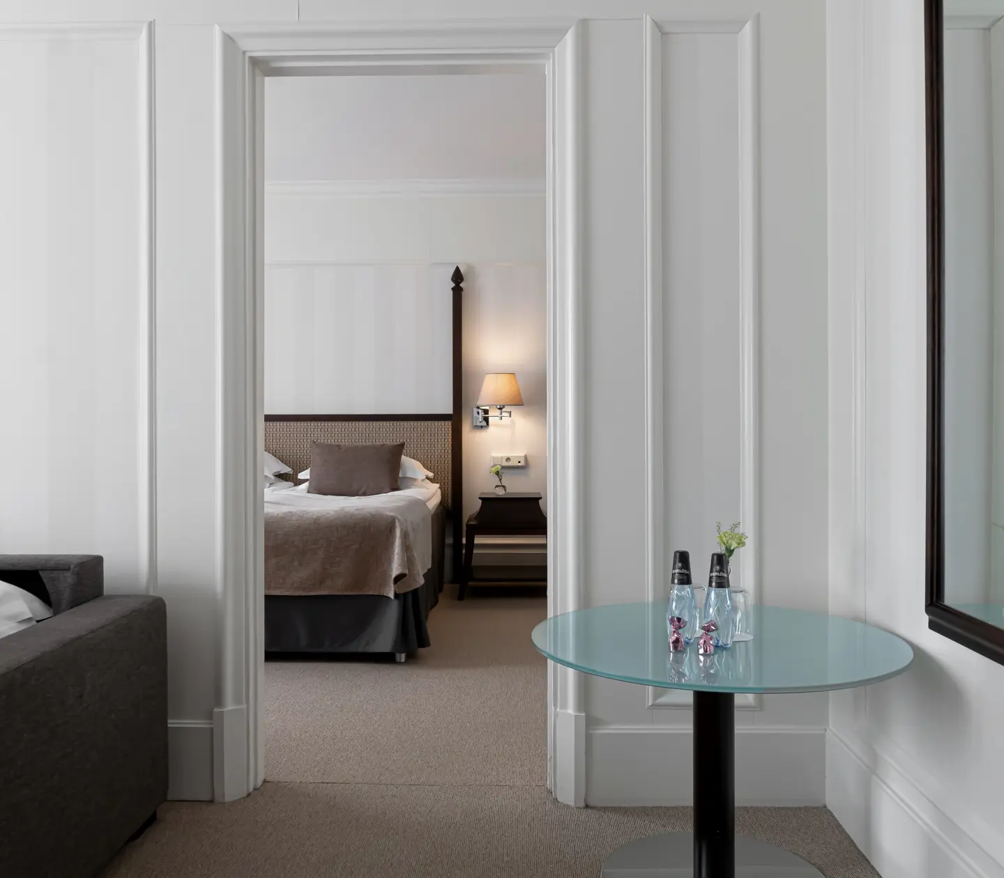 Hotel room with two rooms with bed, sofa and mirror