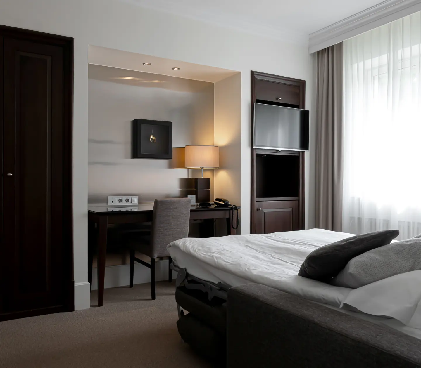 Hotel room with double bed, desk and TV