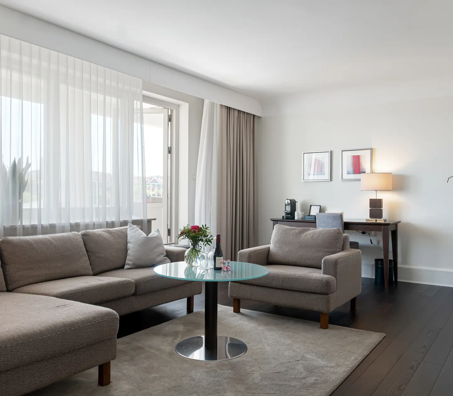 Suite with large sofa, desk and balcony door
