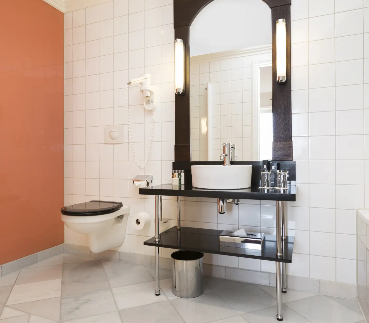 Bathroom with orange wall, sink and toilet