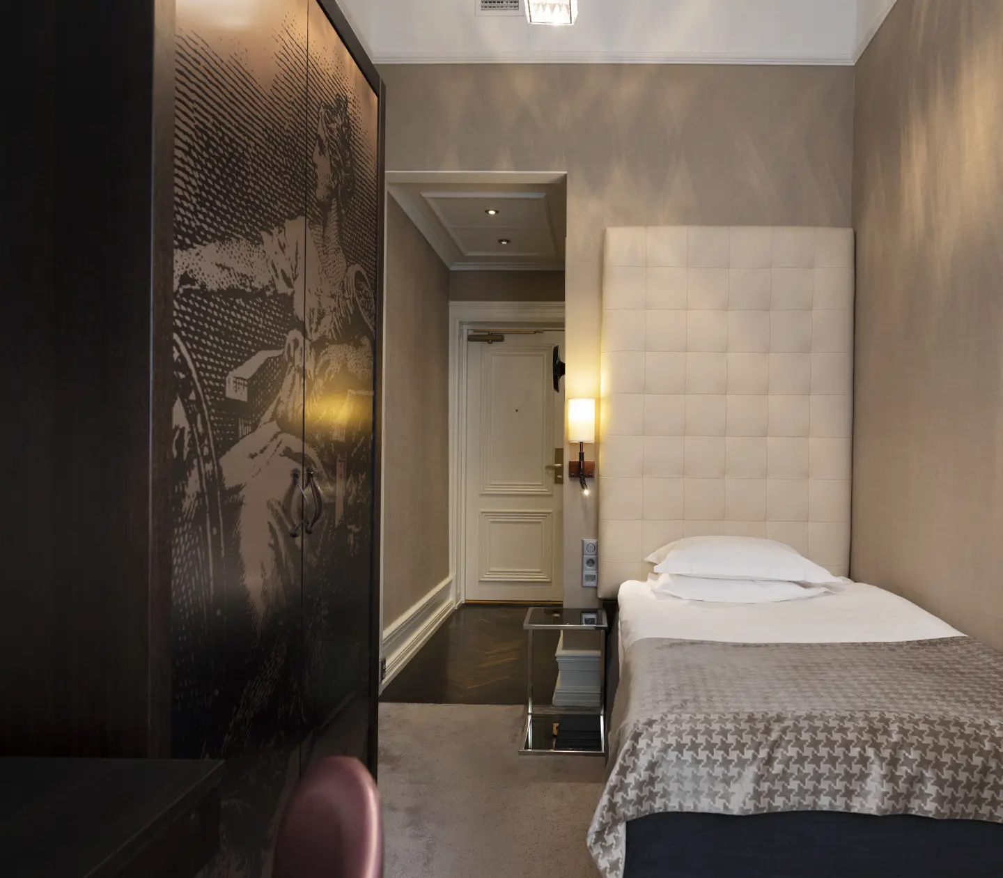 Small hotel room with bed and wardrobe