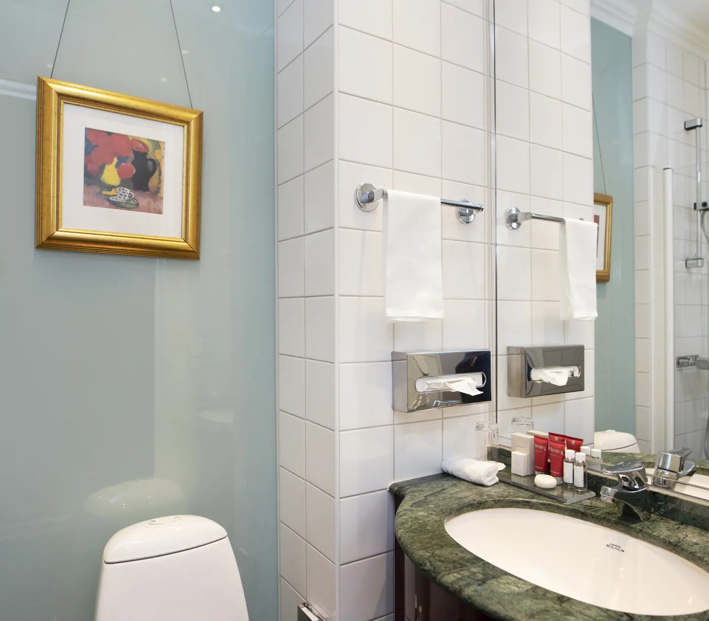 Bright bathroom with toilet, sink and shower