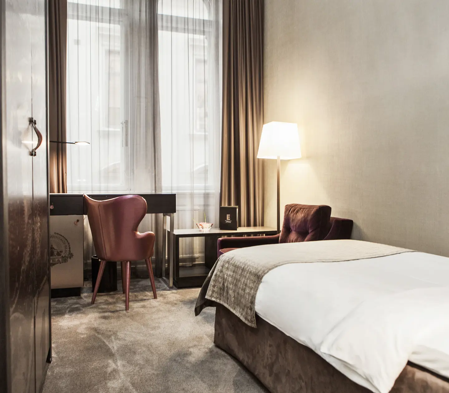 Cozy hotel room with single bed, desk and large windows