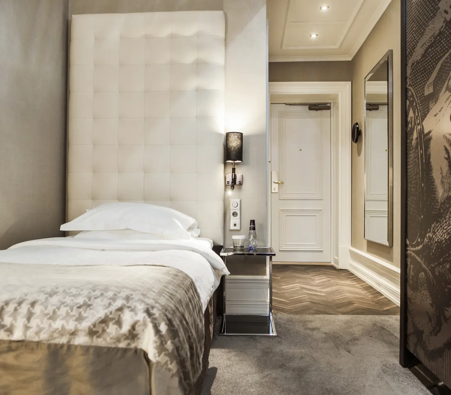 Bright hotel room with single bed and wardrobe