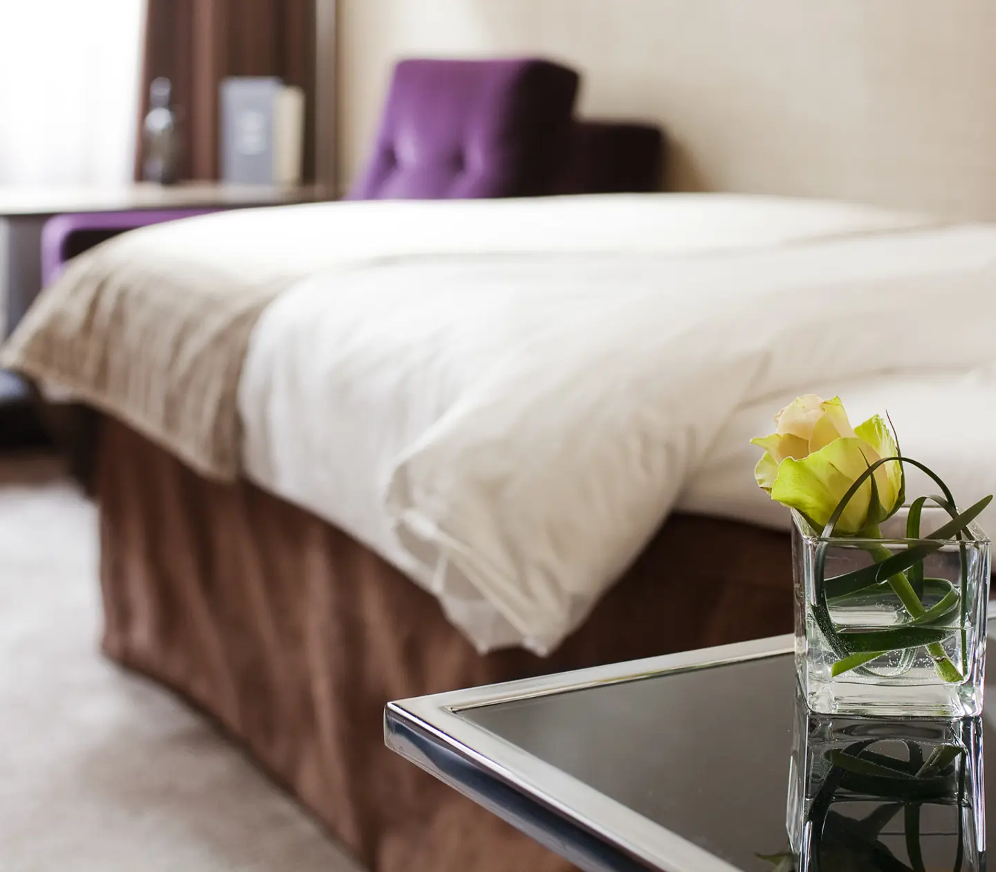 Detail image of flower with bed and armchair in the background