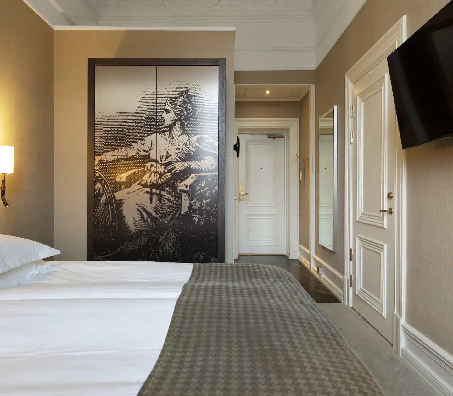 Hotel room with bed, large headboard and wardrobe