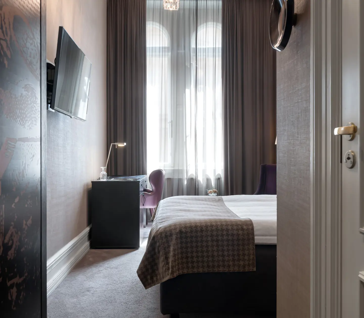 Hotel room with bed, desk and large window